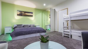 A bedroom with a bunk bed, a bedside table, a nightstand, a potted plant, and a painting on the wall. - Penmoor Chance - Old Town (Bratislava)