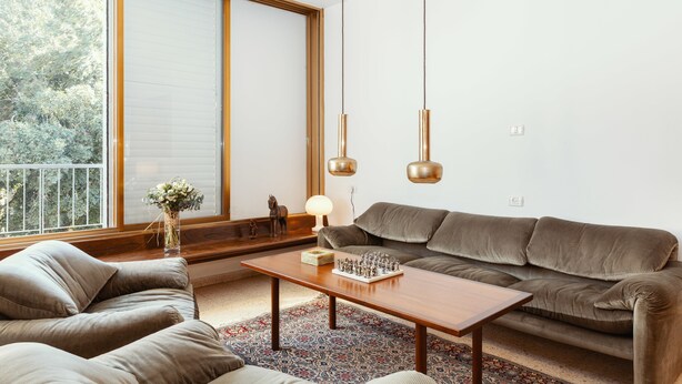 Una sala moderna con un sofá, una mesa de centro y un tablero de ajedrez.