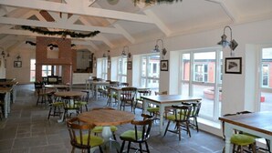 A spacious dining area with high ceilings, brick fireplace, and large windows. - The Aston Tavern (Birmingham)