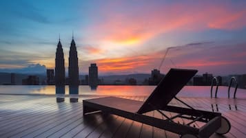 Una piscina techada, una piscina al aire libre, sombrillas