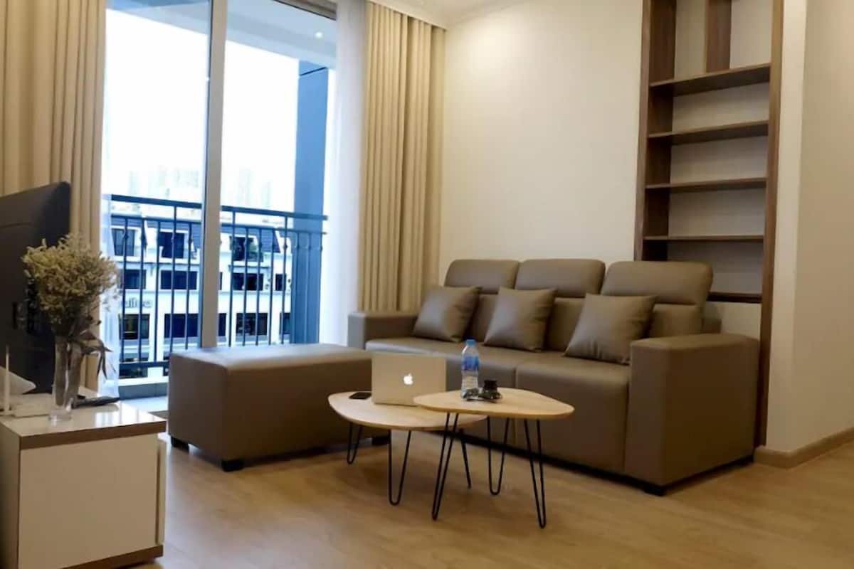 A modern living room with a sofa, a coffee table, and a TV on a stand.