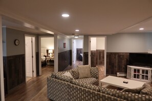A living room with a patterned sofa, a white coffee table, and a TV on a cabinet. - Entire rental unit in Bethlehem, NH (Bethlehem)
