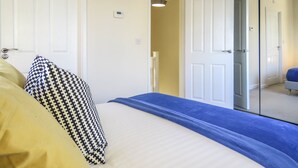 Ein Hotelzimmer mit einem Bett, einem Kleiderschrank und einer Tür zu einem anderen Raum.