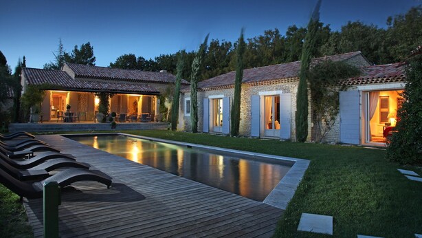 Uma villa com piscina, área de estar externa e fachada de pedra.