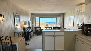 A compact kitchen with a dining area, a view of the outdoors, and a small seating area. - Beachfront Getaway on Park Point - Easy Walking Distance to Canal Park (Duluth)