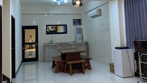 A modern living room with a dining area, a kitchen, and a door leading to another room. - Colorful Guesthouse (Magong)