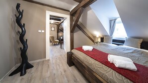 A bedroom with a wooden ceiling, a bed with a red blanket, and a unique black wall sculpture. - OLD TOWN -2 BEDROOM 2 BATHROOM max 8 pers (Prague 1)