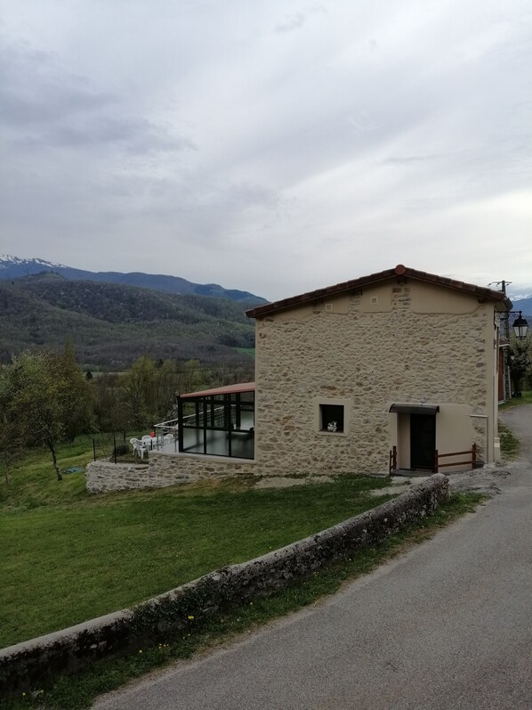 A stone building with a small porch and a glass door.