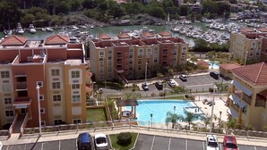 A view of a residential area with a swimming pool, multiple apartment buildings, and a marina with boats. - The best vacation in Puerto Rico (Fajardo)