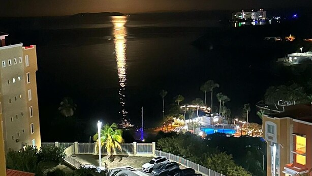 A nighttime view of a coastal hotel with a swimming pool, parking area, and a view of the ocean. - The best vacation in Puerto Rico (Fajardo)