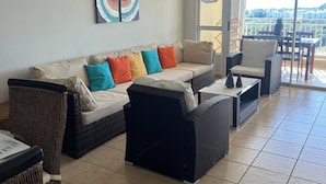 A spacious living area with a sofa set, wicker chairs, and a dining table. - The best vacation in Puerto Rico (Fajardo)
