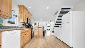 A kitchen with wooden cabinets, a dishwasher, a stove, and a refrigerator.