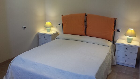 A neatly made bed with a white comforter and two pillows, flanked by two bedside tables with lamps. - Hotel Parco dei Principi (Anzio)