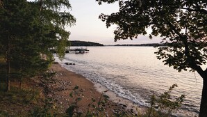 A lakeside view with a dock extending into the water, surrounded by trees and vegetation. - Sea front Ex-Embassy residence near Stockholm (Kummelnäs)