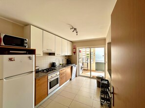 A kitchen with a microwave, stove, oven, and a washing machine.