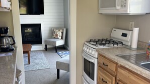 Una cocina con estufa a gas, microondas y chimenea.