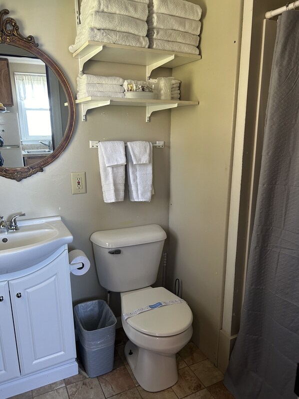 Un baño con inodoro, lavabo y espacio para toallas.