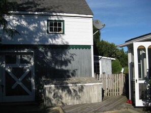 A white building with a garage door, a small window, and a satellite dish. - House by the Bay with Large In-ground Pool, Steps from Beach (East Marion)