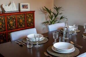 A dining table set with plates, glasses, and cutlery, surrounded by chairs. - Toldino House 4 min. by car to lake (Cernobbio)