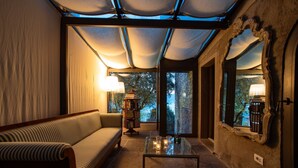 Ein gemütliches Zimmer mit einer Couch, einem Glastisch und einer Lampe.