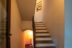 Een trap met een houten leuning en een aan de muur bevestigd schilderij.