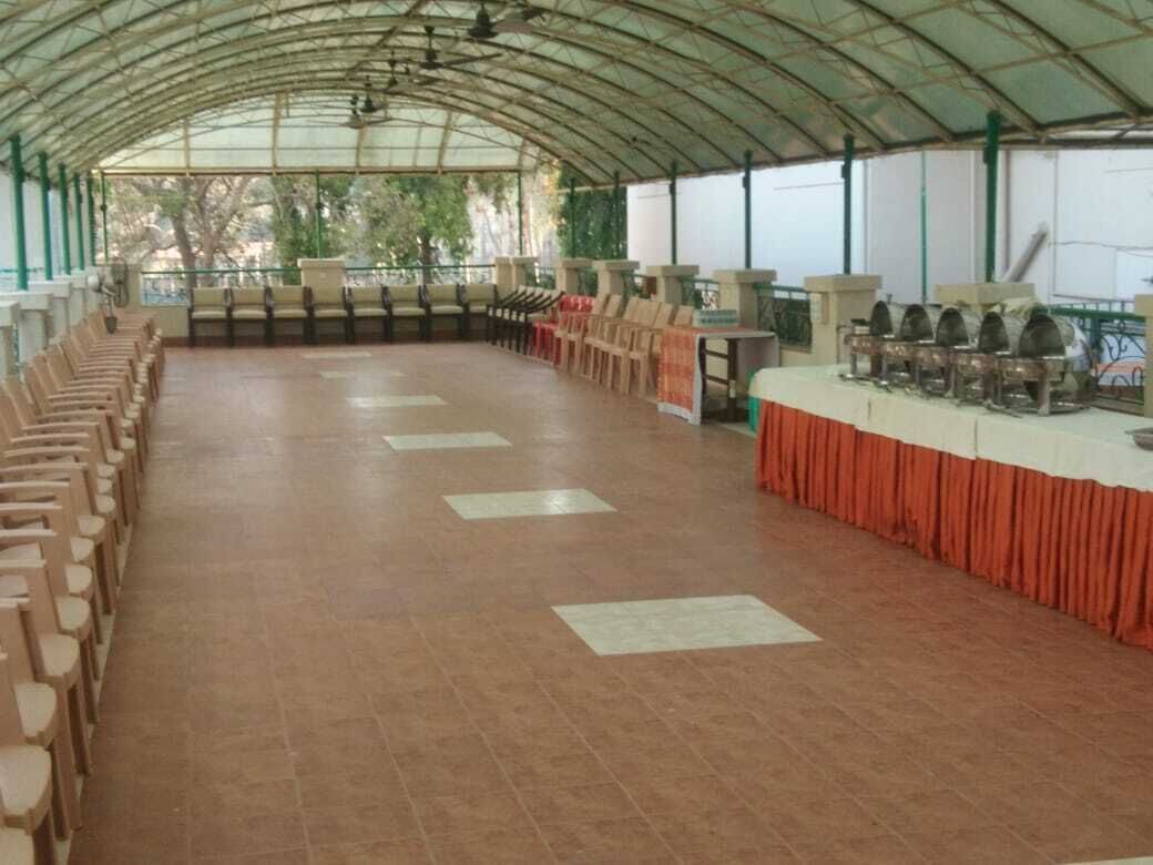 Un espacio al aire libre cubierto con filas de sillas y mesas, probablemente para comer o eventos.