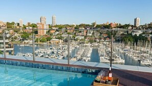 A swimming pool with a view of a marina and cityscape.