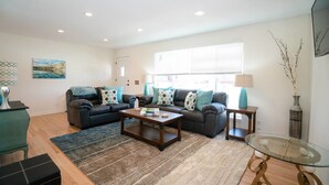A living room with a sofa set, coffee table, and side tables. - The Meadowlark Manor Spacious Backyard & Hot Tub (Lakewood)