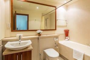 A bathroom with a sink, toilet, bathtub, and a mirror.