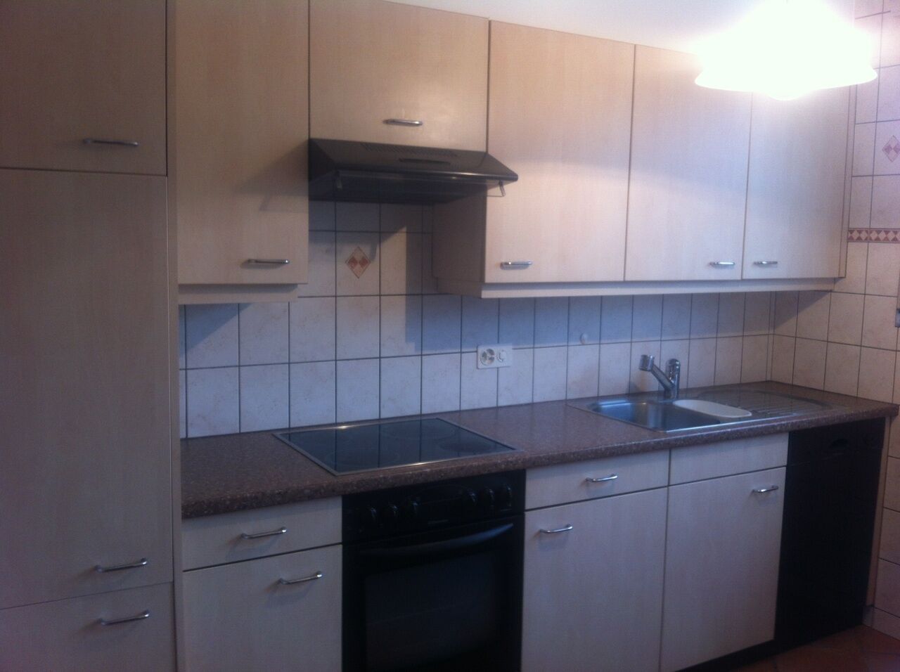 A compact kitchen with a dishwasher, a stove, and a sink.