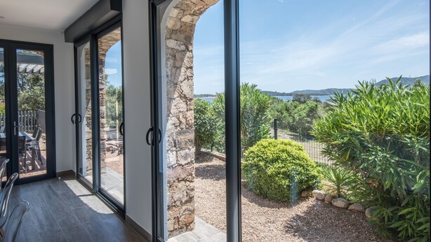 Ein modernes Interieur mit großen Glasüren, die zu einer Außenpatio führen.
