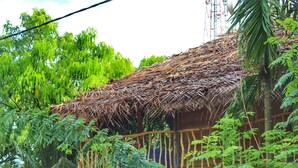 A rustic thatched-roof structure surrounded by lush greenery. - Green Garden Resort (Habarana)