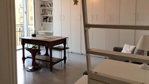 A room with a wooden table, a bookshelf, and a bunk bed.