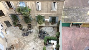 An aerial view of a courtyard with bicycles parked, potted plants, and a small garden area.