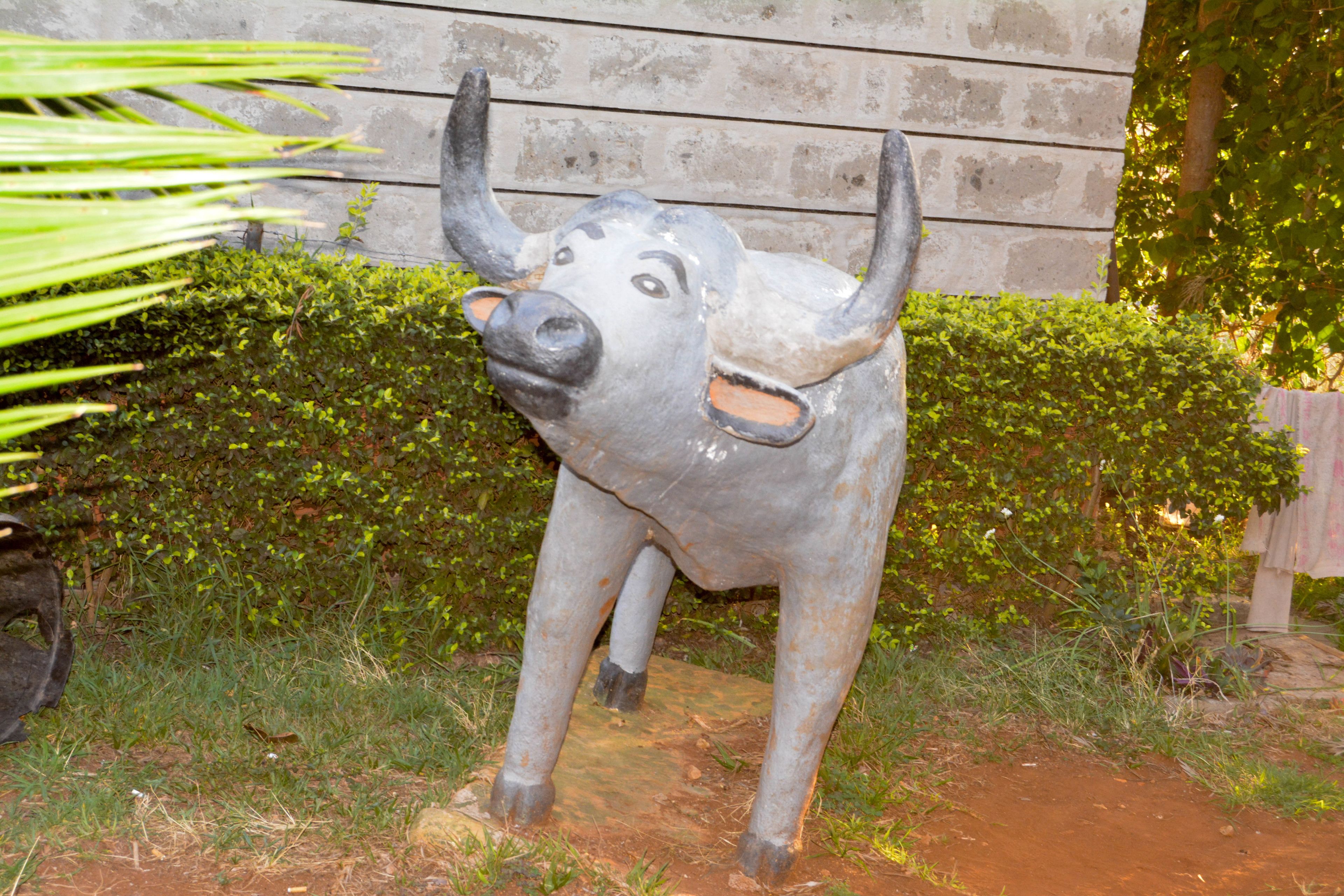 Eine Skulptur eines Stiers in einem Garten.