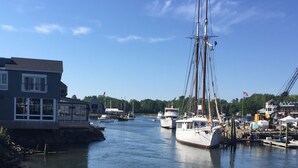 A marina with several boats docked, a building with a balcony, and a clear blue sky. - 4BR, 2 level, comfortable House In Kennebunkport/Cape Porpoise Maine.  (Kennebunkport)
