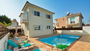 A pool area with lounge chairs and a swimming pool. - Villa Anasta near the sea  (Protaras)