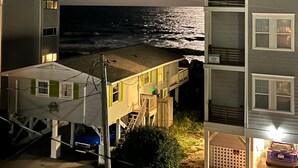 En ejendom ved stranden med havudsigt, en balkon og parkeringsplads.