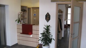 A reception area with a desk, a potted plant, and a wall-mounted decoration. - Hotel Gasthof Goldener Adler (Horb am Neckar)