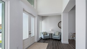 A hallway with two armchairs, a small table, and a lamp. - 4 Bedroom, 4 Bathroom Custom Home with pool! 5 Min Walk to Beach! (Marco Island)