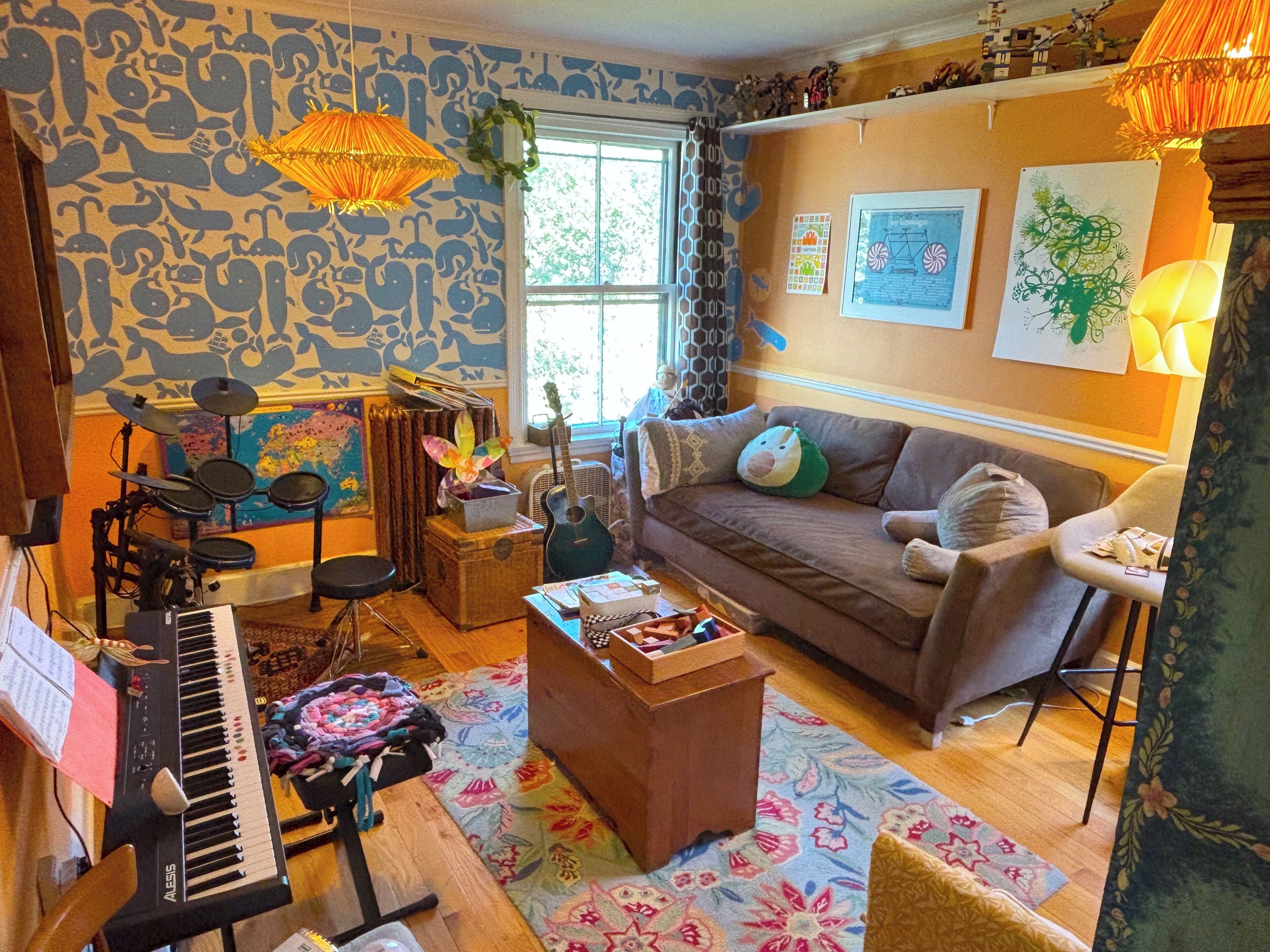 Un salon chaleureux avec un piano, un canapé et une table basse.