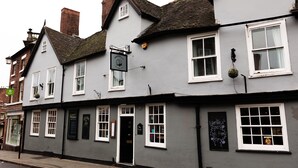 A traditional pub with multiple windows and a black signboard. - Cromwell's Tap House (Shrewsbury)