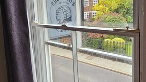 A window with a view of a street, a sign reading "CROMWELL'S TAP HOUSE," and a "9" marking on the window. - Cromwell's Tap House (Shrewsbury)