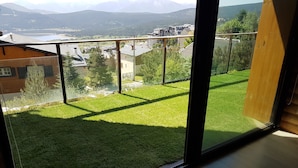 A balcony with a view of a grassy area and buildings in the distance. - Apartment BOUQUETIN in new chalet with view of Lake Matemale sleeps 8 (Les Angles)