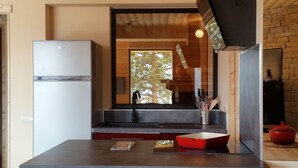 A modern kitchen with a refrigerator, a sink, and a red baking dish on the counter. - Apartment BOUQUETIN in new chalet with view of Lake Matemale sleeps 8 (Les Angles)