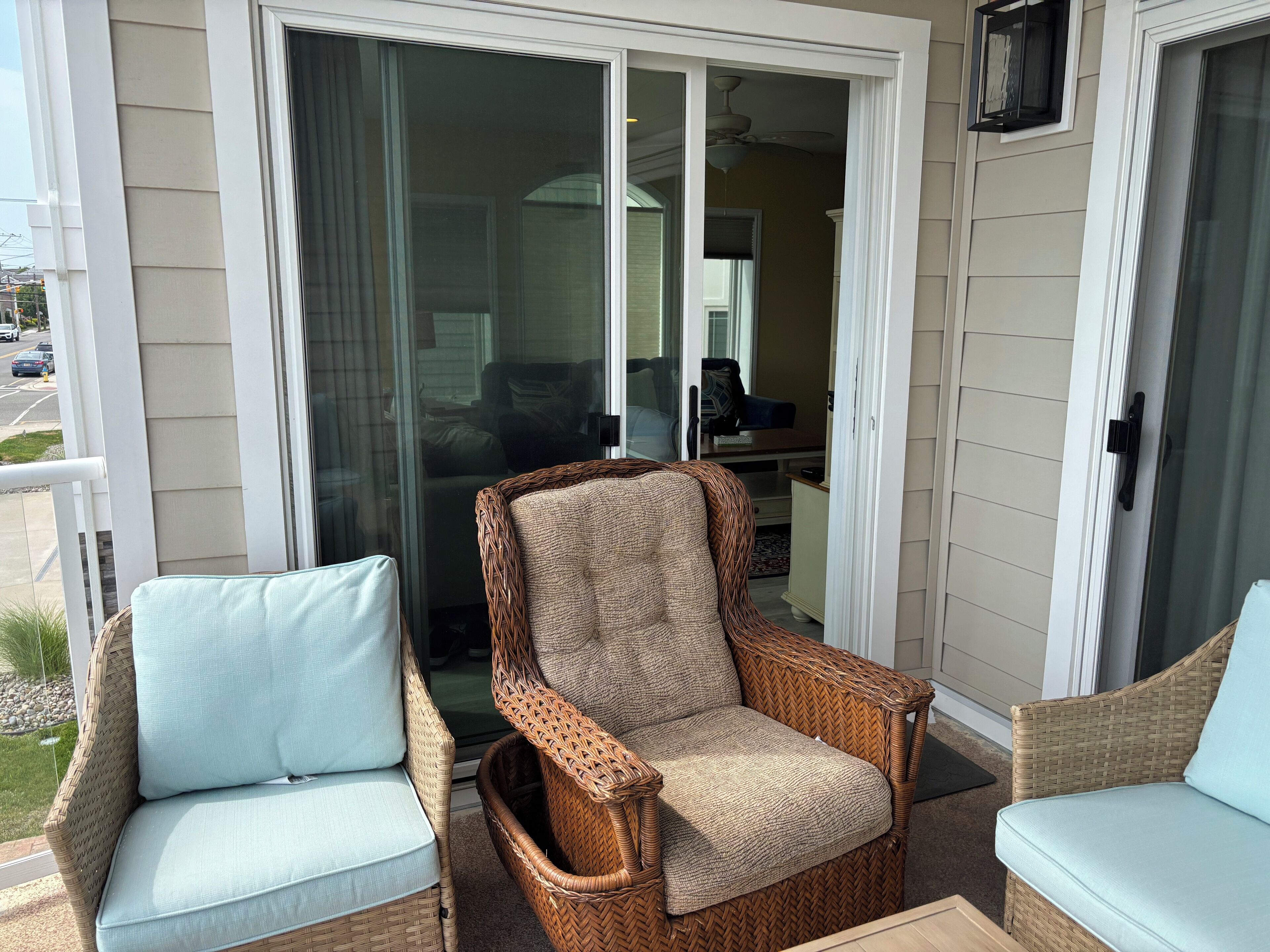 A balcony with wicker furniture and a sliding glass door.