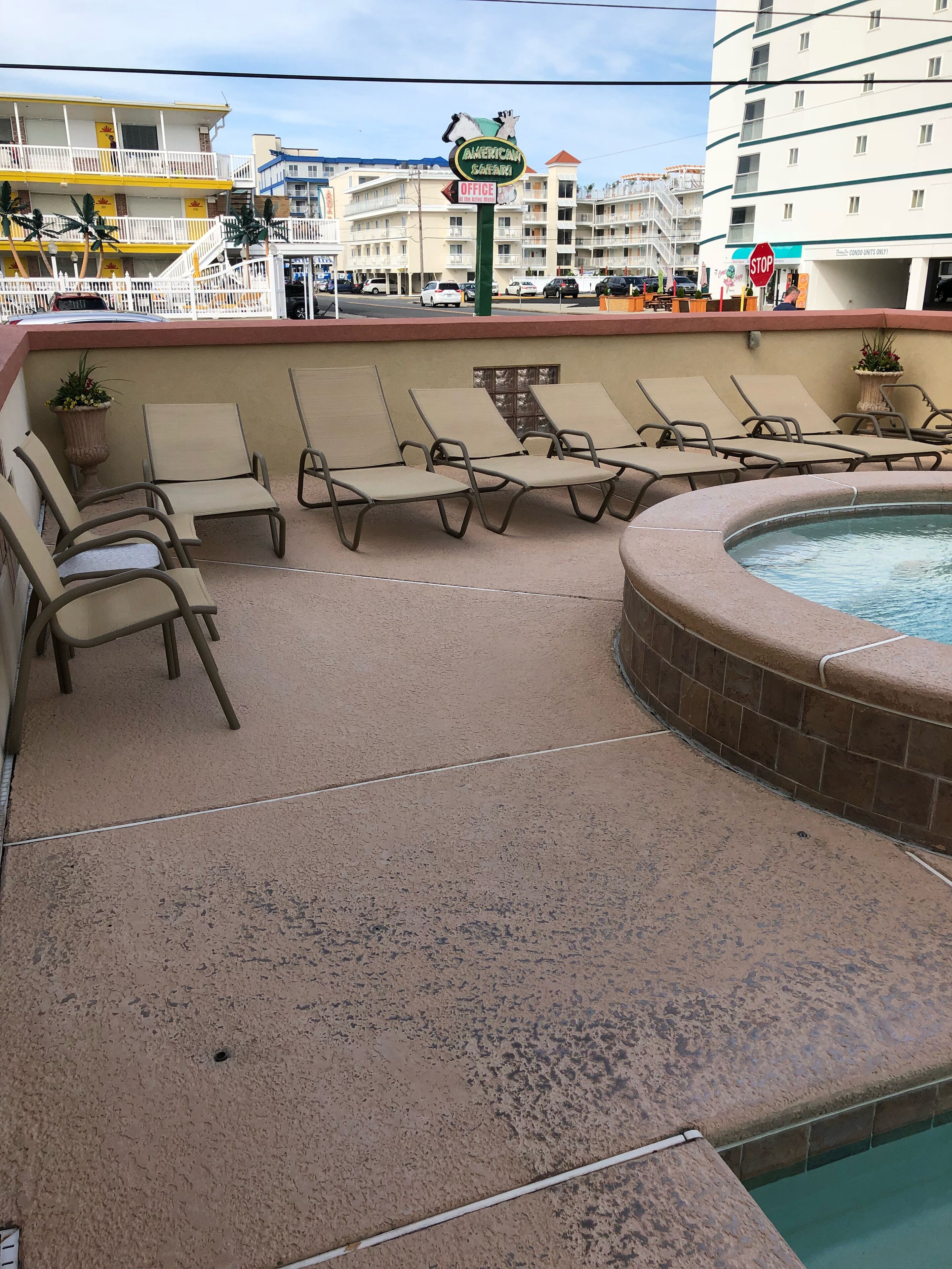Un área de piscina con sillones de descanso y una señal de stop al fondo.