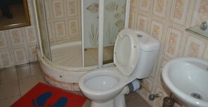 A bathroom with a toilet, bidet, and sink.