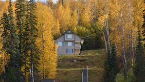 A house with a dock and chairs by a lake, surrounded by autumn trees. - Birch Haven - A Luxury Lakefront Cottage On Pristine Horsefly Lake, with Wifi (Horsefly)