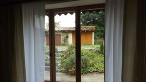 Une pièce dotée d’une porte-fenêtre coulissante donnant sur un jardin.
